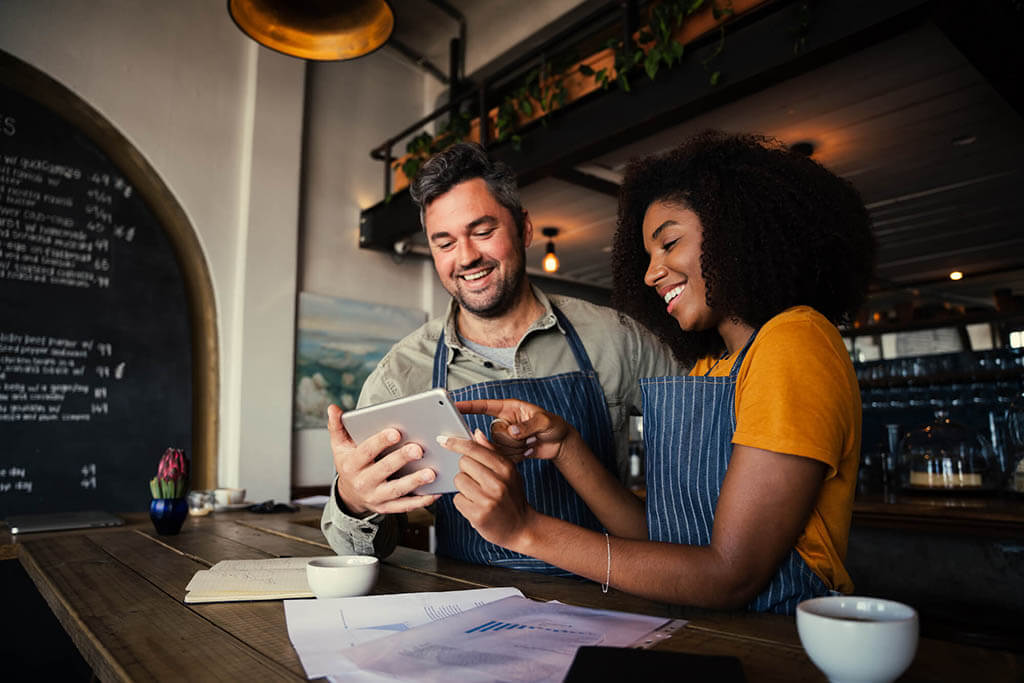 People looking at a tablet in a bar